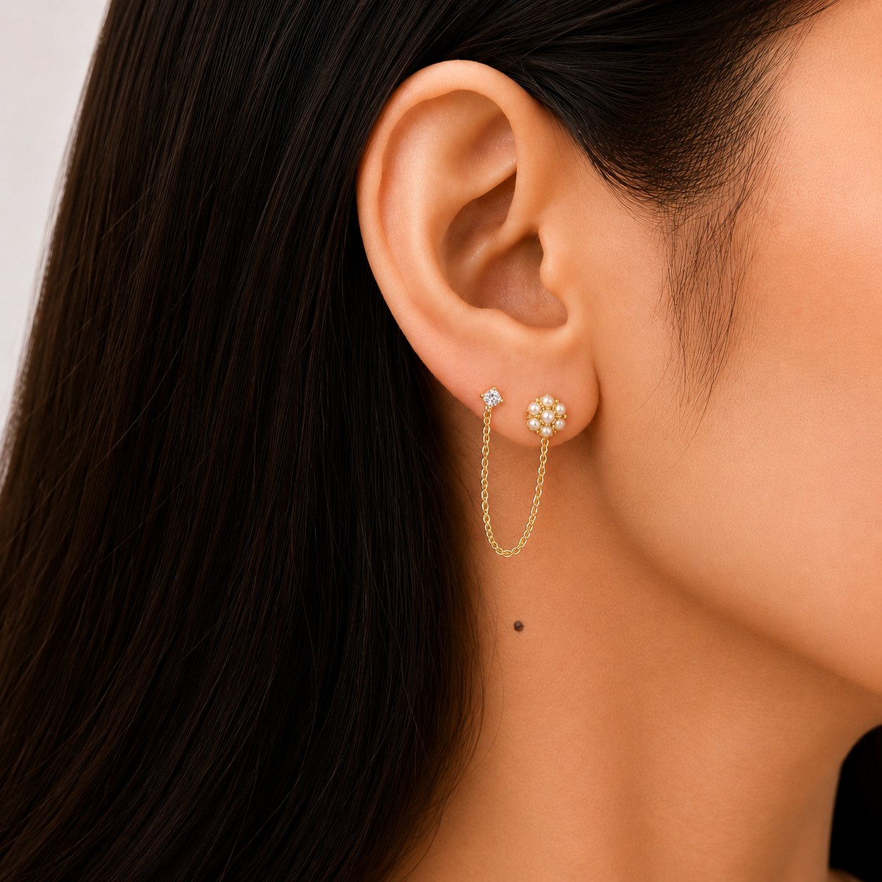 Model wearing waterproof 18K gold plated pearl bloom chain drop earrings with anti-tarnish stainless steel finish.